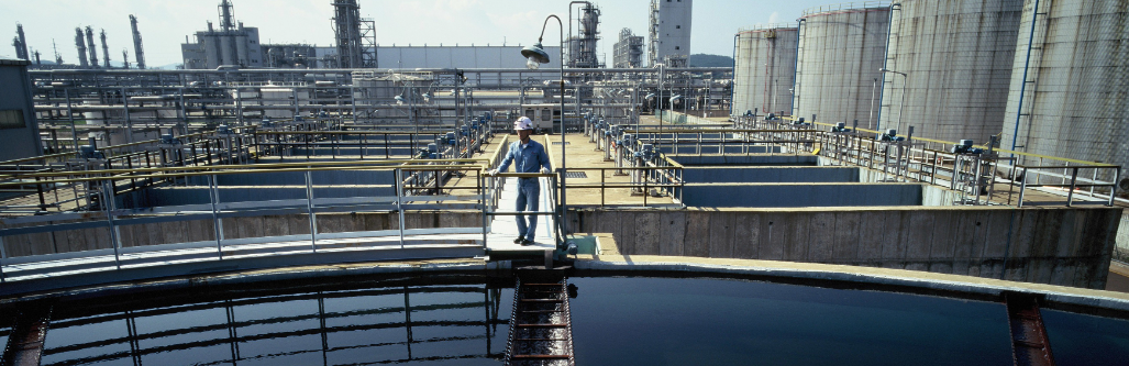 Industrial wastewater treatment plant with a Veolia engineer inspecting water processing at a petrochemical facility in South Korea.