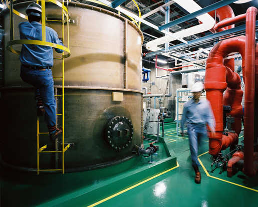 Industrial carbon capture process in South Korea – technician operating CCUS equipment in a petrochemical facility.